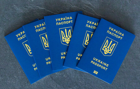Ukraine passports stacked. Ukrainian biometric passport. Emigration concept. High quality photo. Ukrainian passport close-up. On a&nbsp;dark background. Travel concept with Ukrainian passport.