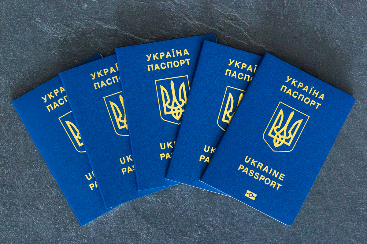 Ukraine passports stacked. Ukrainian biometric passport. Emigration concept. High quality photo. Ukrainian passport close-up. On a&nbsp;dark background. Travel concept with Ukrainian passport.